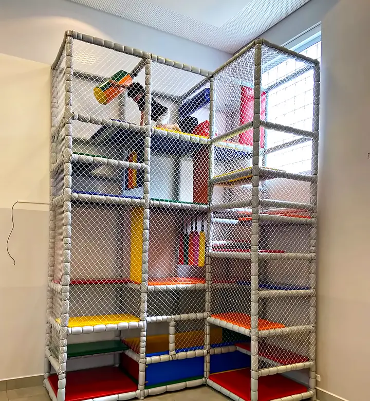 Brinquedão de três andares com rede de proteção, escorregador e obstáculos coloridos