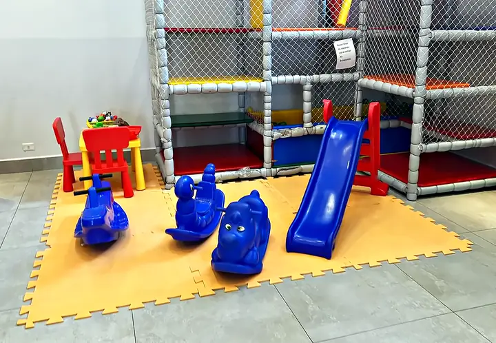 Espaço baby com tatame, escorregador, gangorras e mesinha infantil