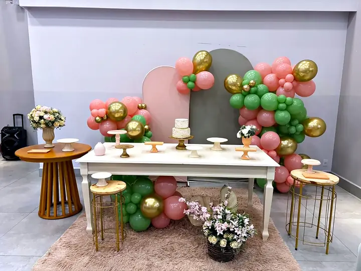 Mesa rosa, verde e dourada com arranjos de flores